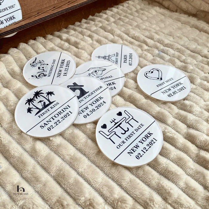Round white stickers with black text and graphics on a textured beige surface