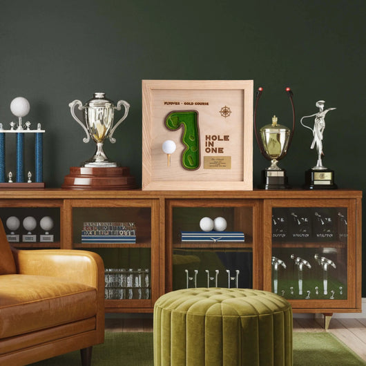 Wooden cabinet with golf-themed trophies and decor against a dark green wall.