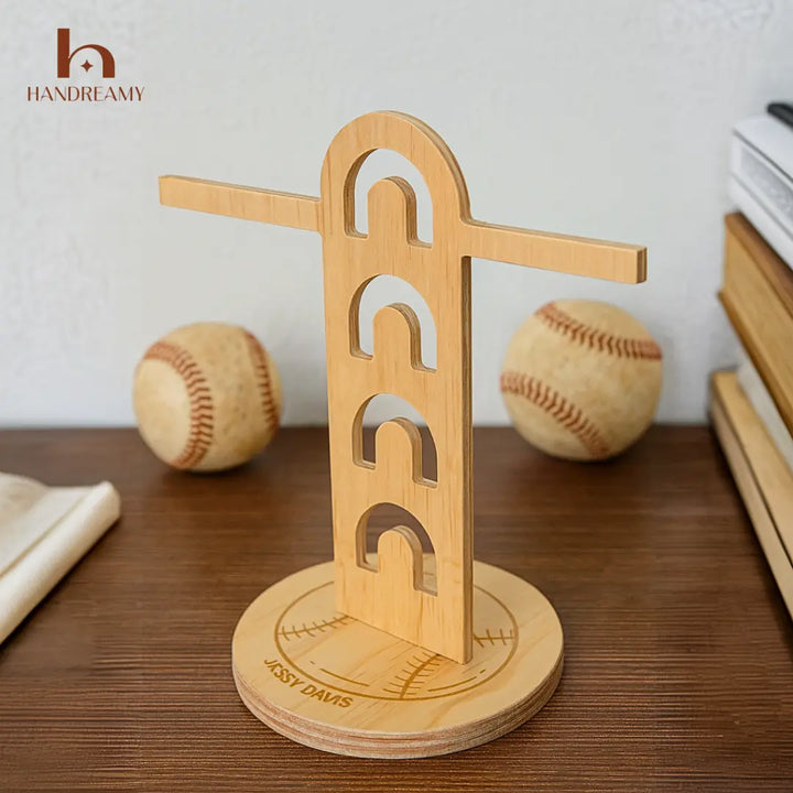 Wooden baseball tee with 'Handreamy' branding on a wooden surface with baseballs in the background.