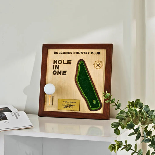Framed plaque with 'Hole in One' design and Balcones Country Club text on a white surface.