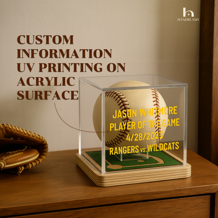 Baseball in a clear display case with personalized text on an acrylic surface, next to a baseball glove.