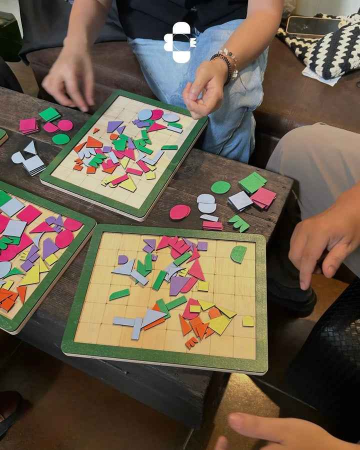 Children playing with colorful puzzle boards on a wooden table.