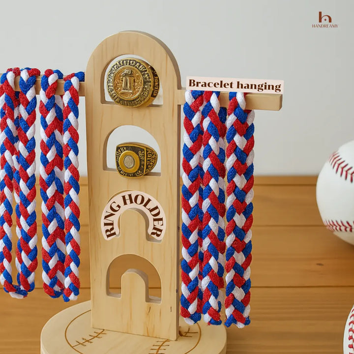 Wooden bracelet holder with braided red, white, and blue bracelets on a wooden surface.