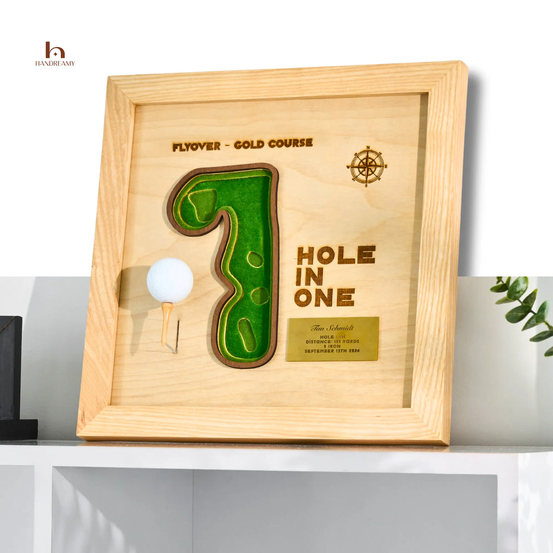 Wooden plaque with golf design and 'Hole in One' text on a shelf.