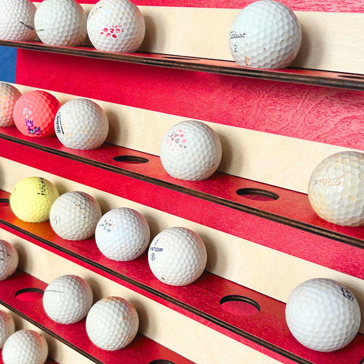 Golf balls arranged on a wooden and red background