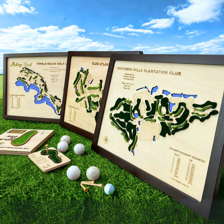 Framed golf course maps on grass with golf balls and tees