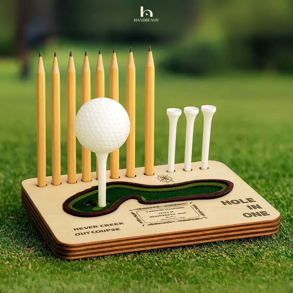 Golf ball and tees on a wooden holder with 'Hole in One' text on grass