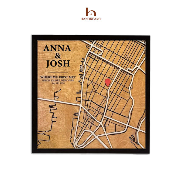 Wooden map with engraved text and a red heart, framed by Handreamy brand.