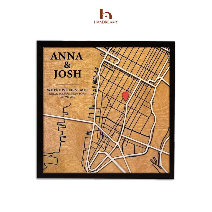 Wooden map with engraved text and a red heart, framed by Handreamy brand.