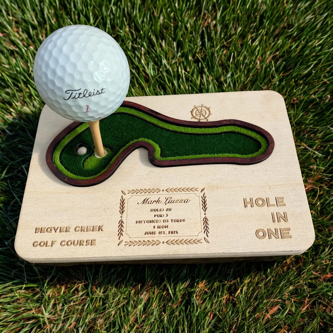 Golf ball on a wooden plaque with golf course details on grass